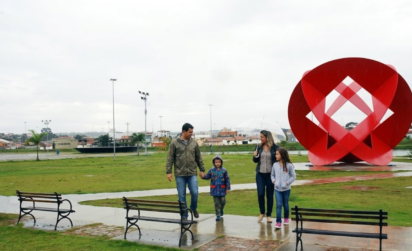 Grupo de família visitando o Parque das Águas em Sorocaba em um dia ensolarado, com crianças e adultos aproveitando o espaço verde