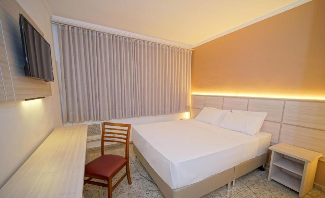 Quarto confortável do Golden Park Sorocaba com área de descanso e mesa de trabalho