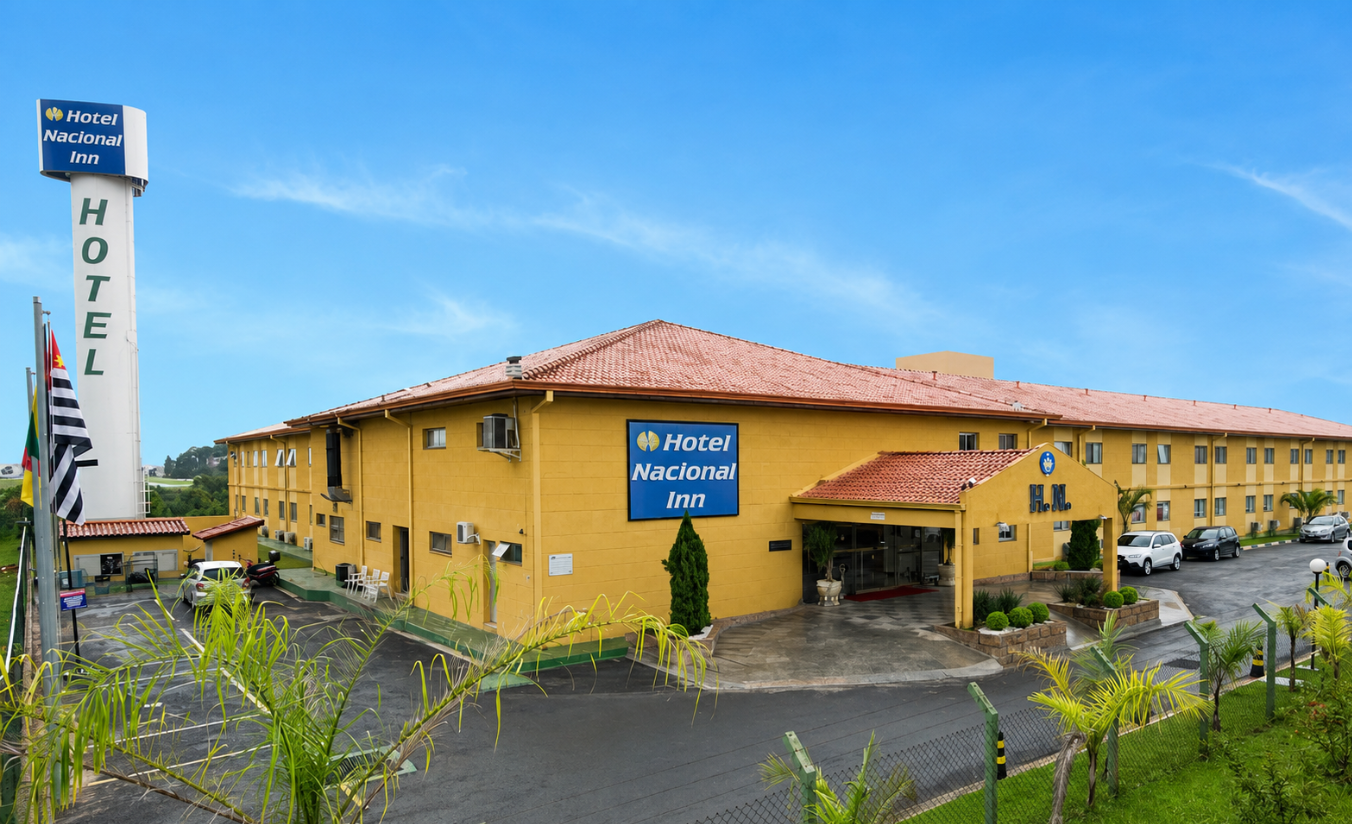 Fachada de hotel moderno à beira de rodovia, cercado por vegetação, representando hospedagem estratégica em Sorocaba