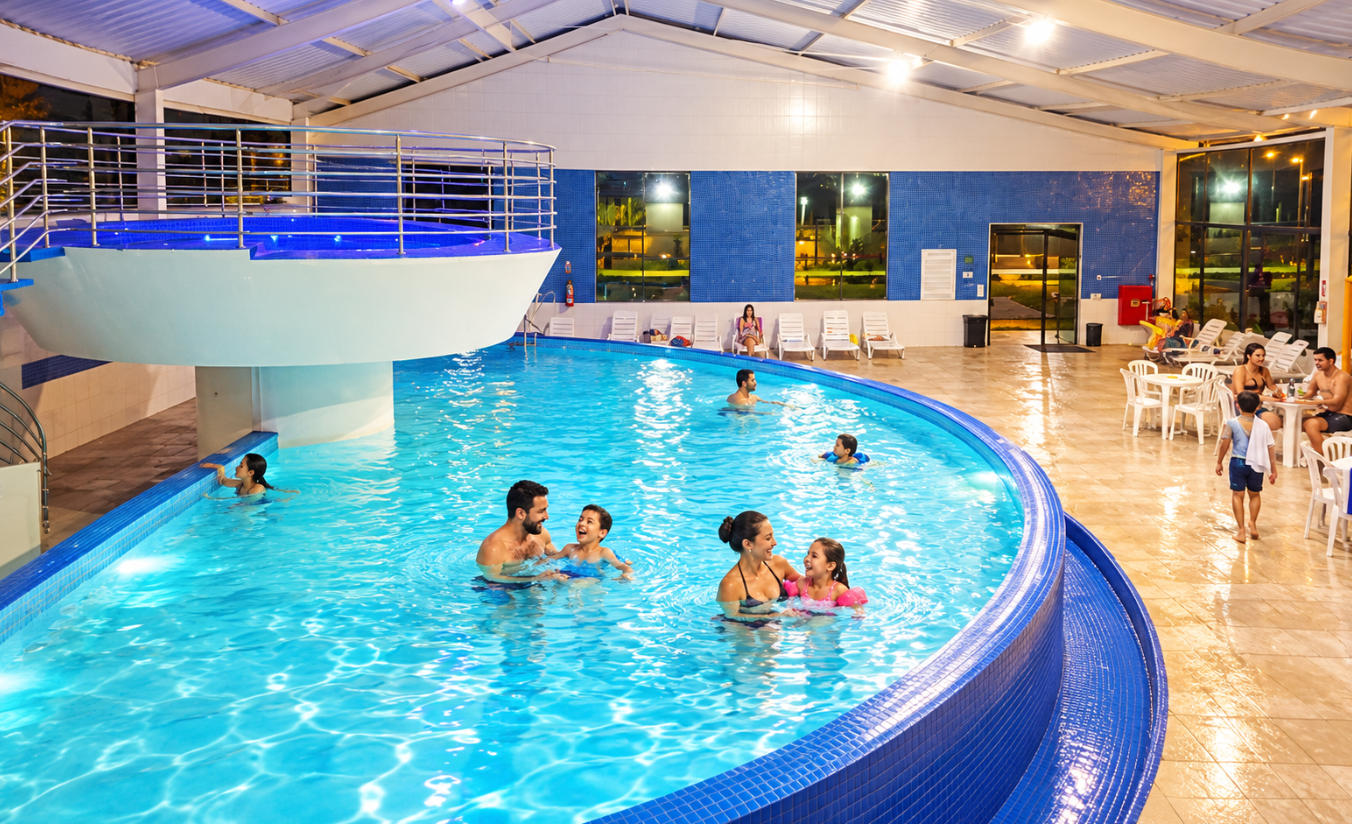 Família com crianças brincando na piscina coberta e aquecida de um hotel de lazer em Sorocaba